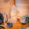 Close-up of various healing crystals on a wooden table with warm lighting